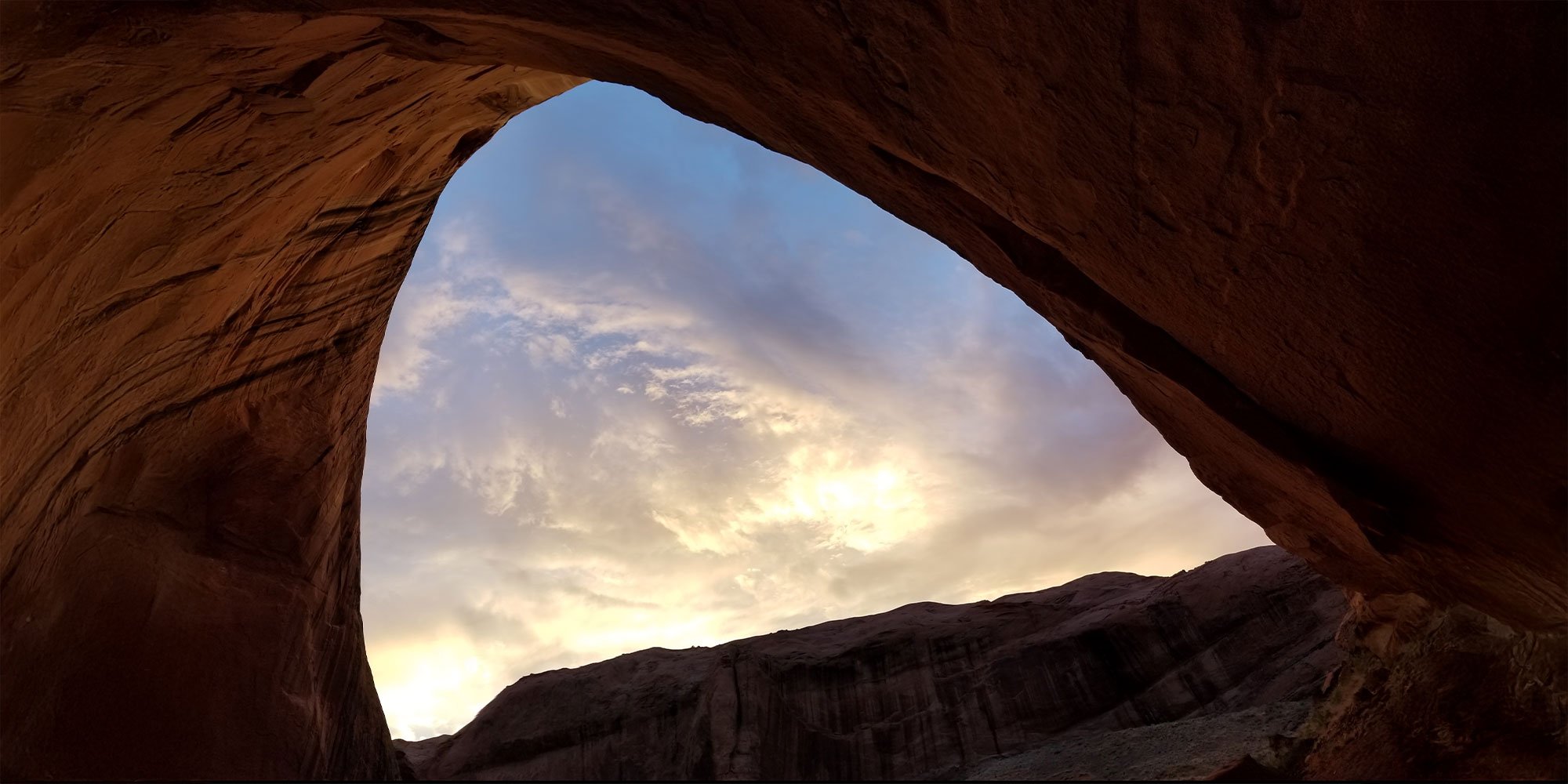 Morning sunrise light through cave opening mountain formation