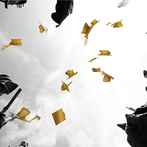 black and gold graduation caps being thrown in the air