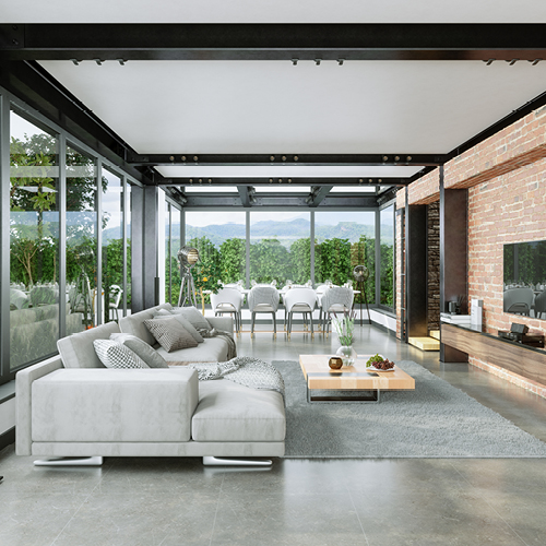 Modern and luxurious living room with two walls of windows overlooking a beautiful yard