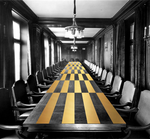 A large rectangular conference table with a gold checkered top in conference room