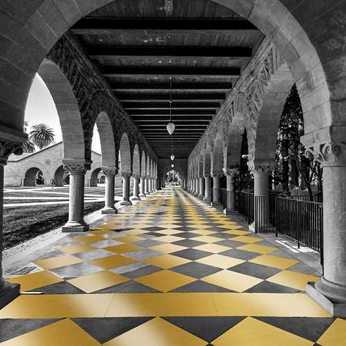 a long covered sidewalk with detailed arches and a black and gold checkered floor