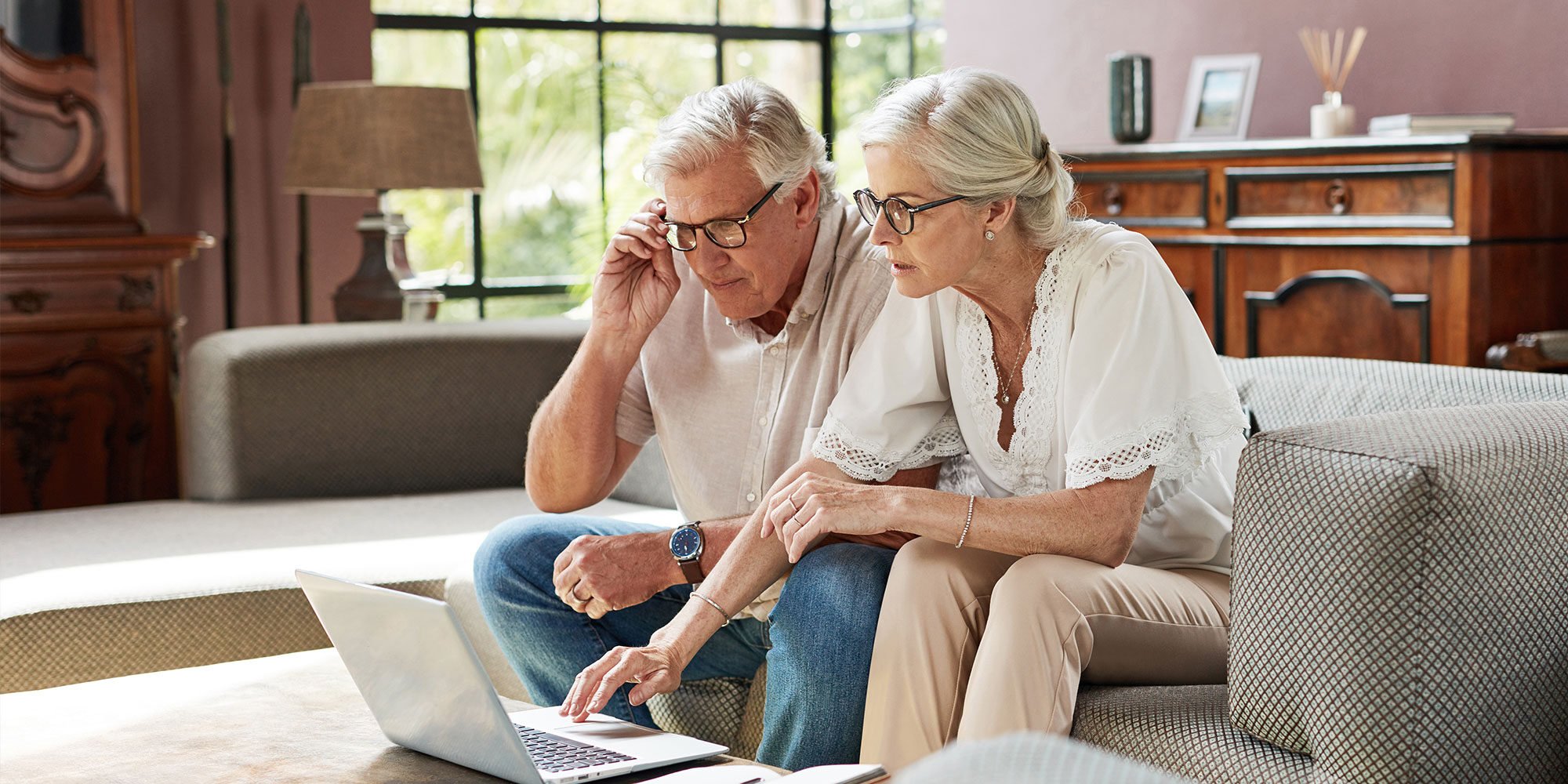 Shot of a mature couple using a laptop while calculating their finances together at home