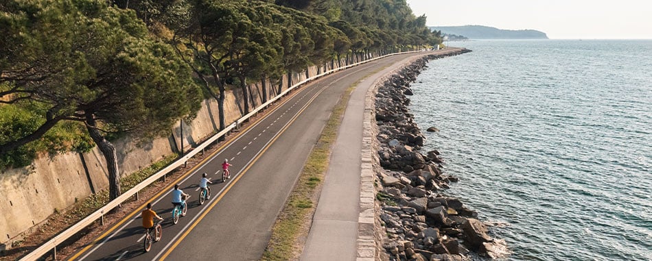 Family biking along lake coast