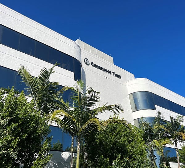 The front outside of the Commerce Trust Commerce Bank building in Naples, Florida with Palm Trees and a blue sky