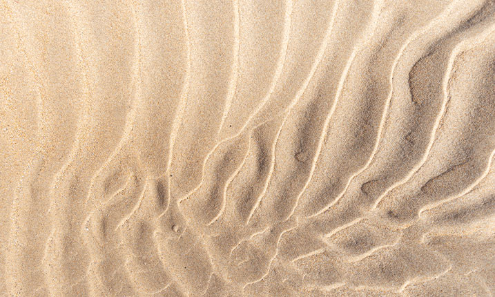 Close up image of waves in the hot sand in the beach
